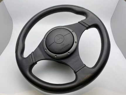 Original OEM Mitsubishi Lancer Evolution (Evo VII, VIII, IX) MOMO leather steering wheel featuring an integrated SRS airbag module and distinctive 3-spoke design.