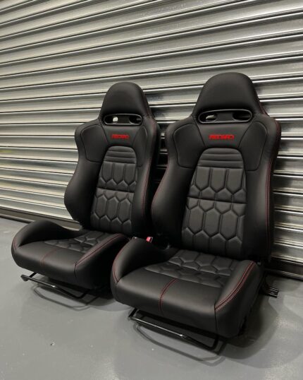 These are brand new Original OEM custom-upholstered front and rear Recaro sport bucket seats featuring black synthetic leather with red contrast stitching and a distinctive geometric honeycomb pattern on the center inserts.