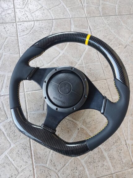 custom carbon fiber and perforated leather re-trim of an OEM MOMO steering wheel designed for the Mitsubishi Lancer Evolution 7, 8, or 9 (CT9A) platform.