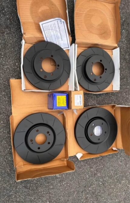 Set of four black slotted Brembo Max performance brake rotors displayed inside their open packaging boxes for lancer evo 8