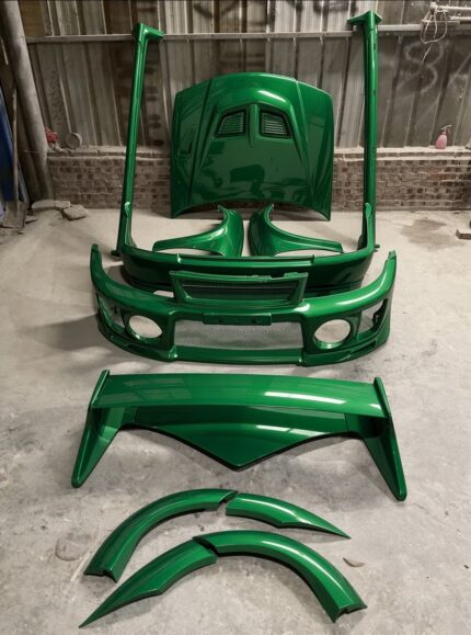 Conversion body kits for a Mitsubishi Lancer Evolution V / VI (CP9A platform), finished in a high-gloss metallic emerald green paint job.
