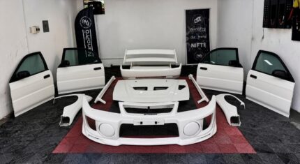 Mitsubishi Lancer Evolution V (Evo 5) complete body conversion kit, which includes structural body panels like the four widebody doors, wide front fenders, wider rear quarter panel flares, vented hood, trunk lid, rear wing spoiler, side skirts, rear bumper and the front bumper..