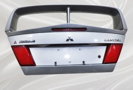 Brand new OEM boot lid and high-profile rear spoiler assembly from a fifth-generation Mitsubishi Lancer Evolution V (CP9A), complete with factory tail lights, center garnish, and Mitsubishi/Lancer badging.
