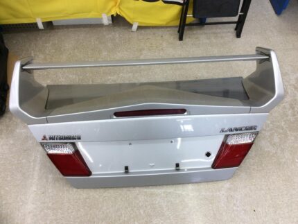 OEM boot lid and high-profile rear spoiler assembly from a fifth-generation Mitsubishi Lancer Evolution V (CP9A), complete with factory tail lights, center garnish, and Mitsubishi/Lancer badging.