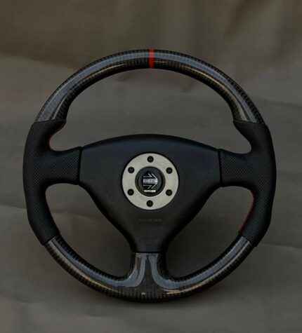 Brand New discontinued Custom MOMO Carbon Fiber Steering Wheel designed for a Mitsubishi Lancer Evolution IV, V, or VI, featuring carbon fiber top and bottom sections, perforated leather side grips, red accent stitching, and a red top-center marker.